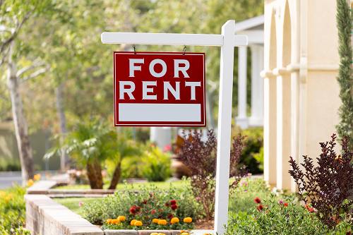 A "For Rent" sign outside a home.