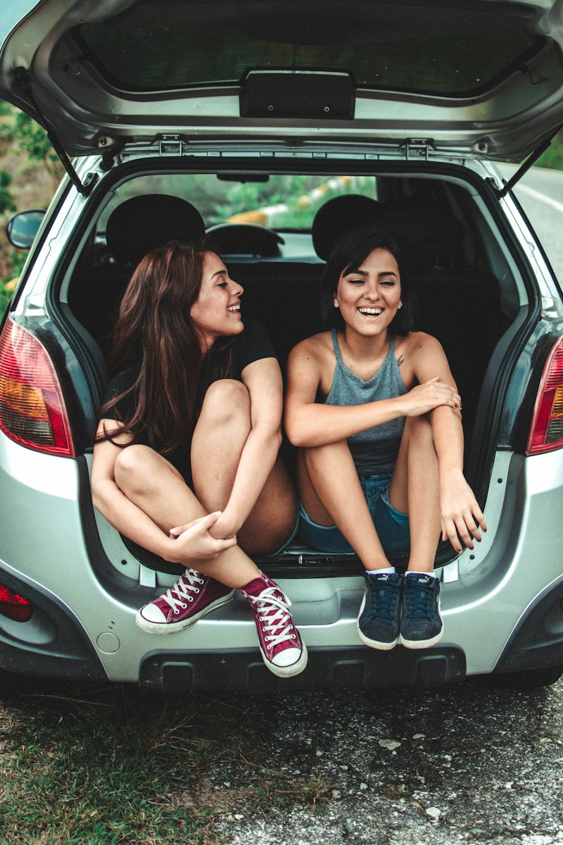 two women sitting at the back of the car discussing car warranty and car insurance